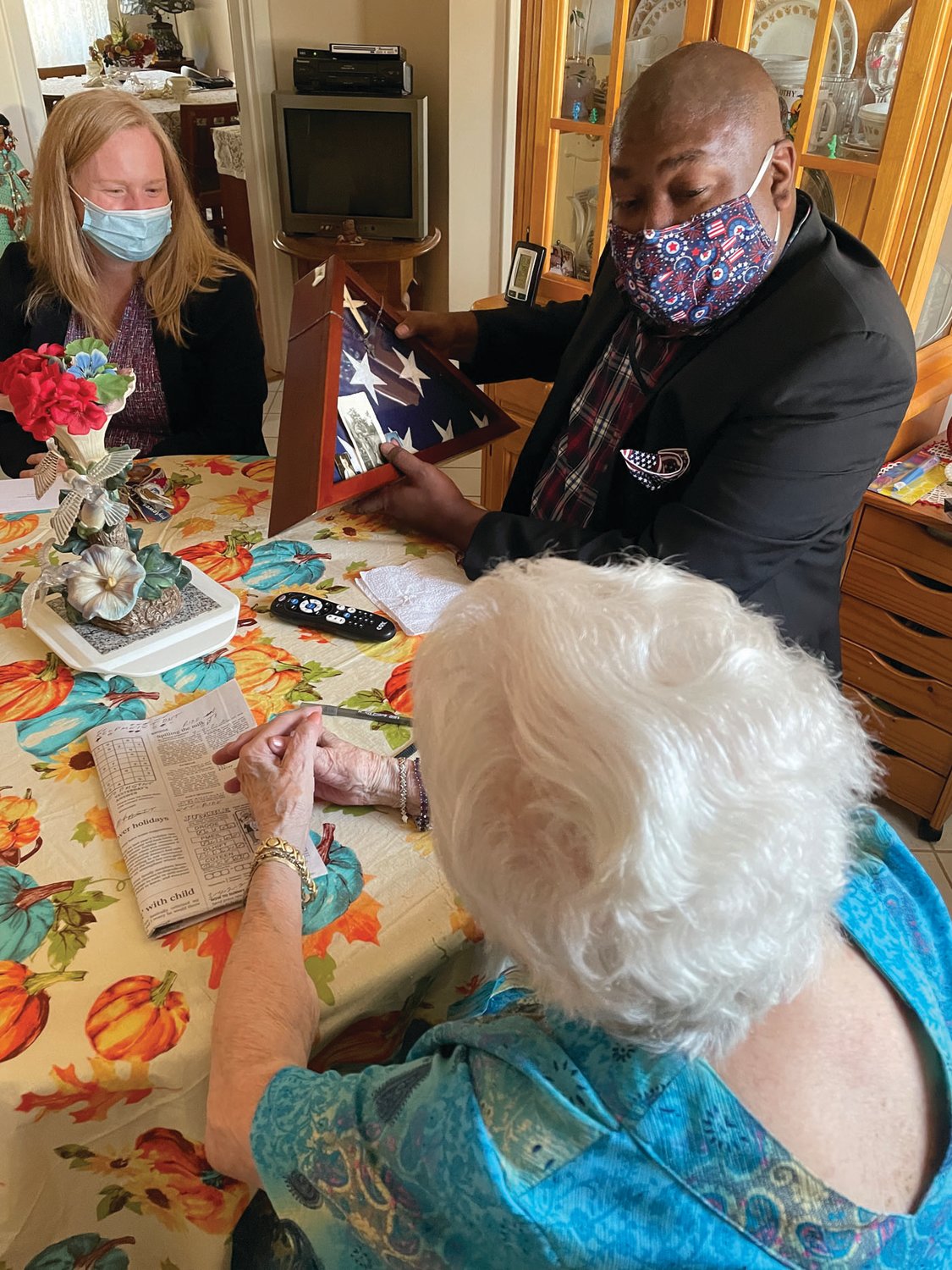 COMING TOGETHER: Theresa Brennan welcomes Meals on Wheels Executive Director Amy Grady and RI Veteran Affairs Director Kasim Yarn to sit around her table. Her late husband, George A. Brennan, served overseas during WWII.